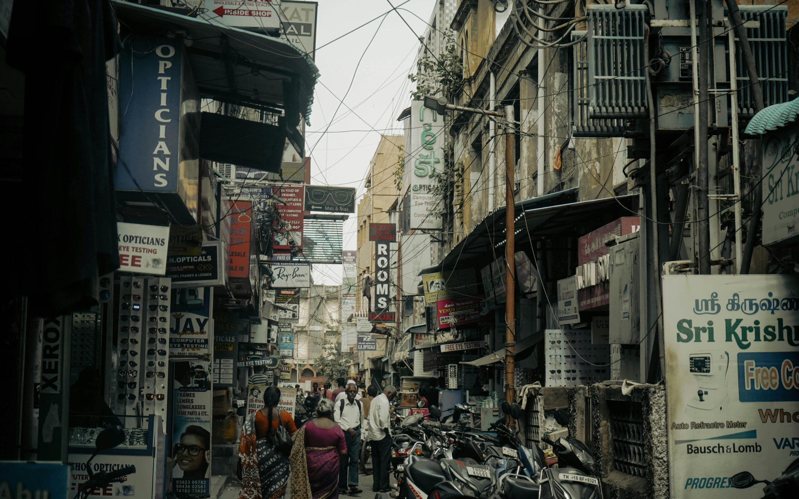 Busy street in Chennai with people and shops lining the alleyway, capturing urban life.