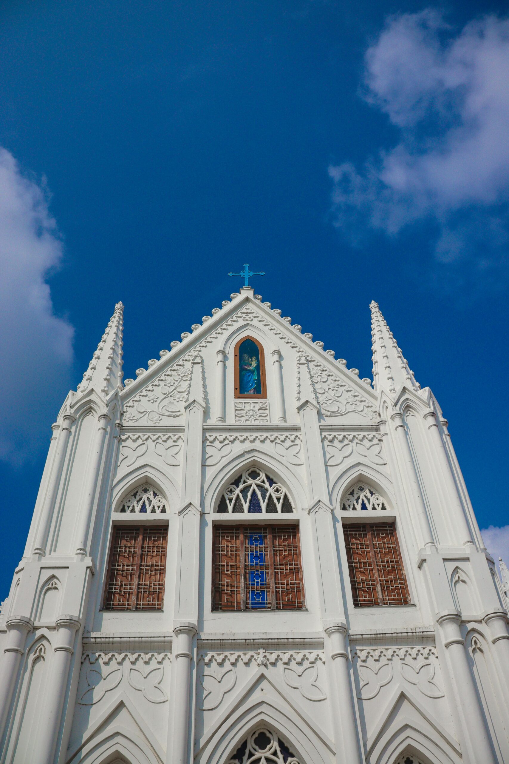Explore the intricate Gothic architecture of the iconic Velankanni Church in Tamil Nadu against a clear blue sky.